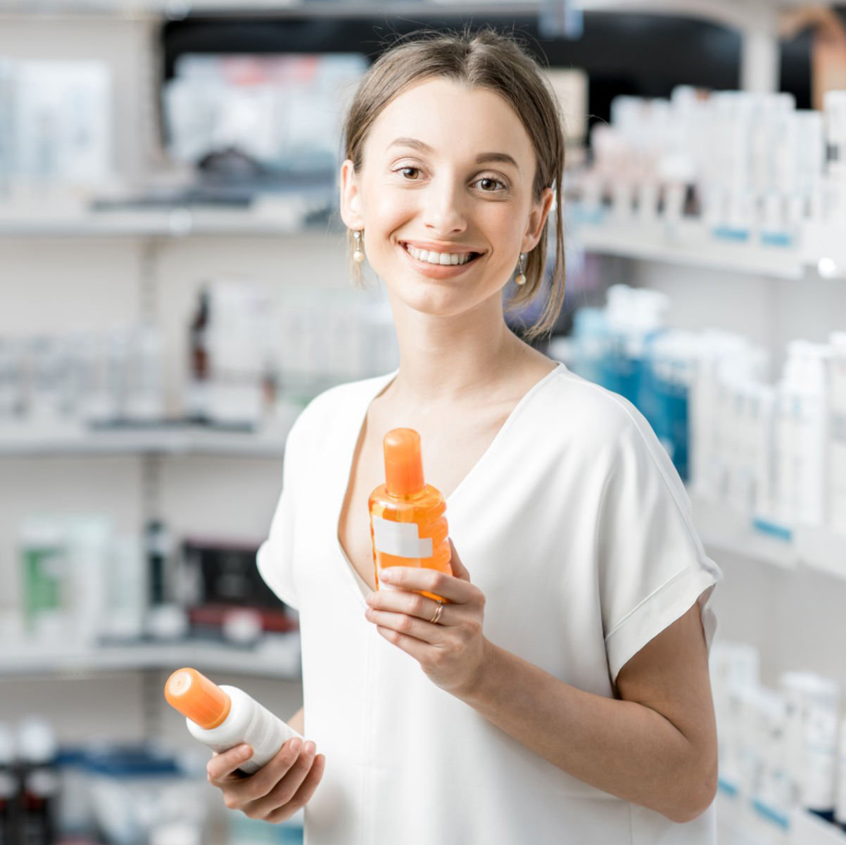 Young woman customer choosing sunscreen lotion at the pharmacy store